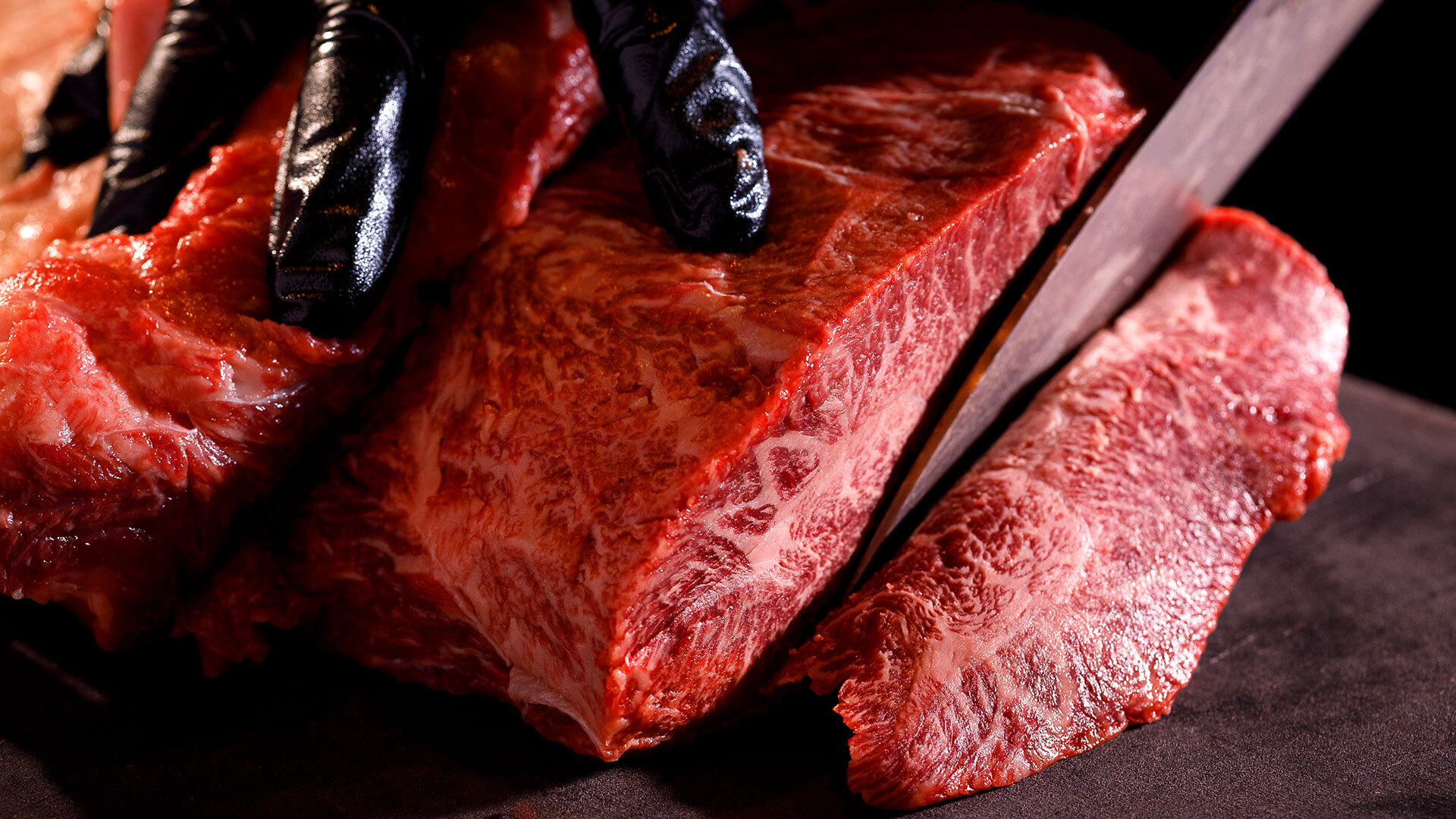 『焼肉 東京24区』：ミスジ￥880（1枚）。まぐろのサクを切るかのように、注文を受けたら冷蔵庫から塊肉を取り出し、その部位のベストな厚みにカット